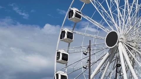 White ferris wheel rotates against clean blue sky. Stock Footage 336448214