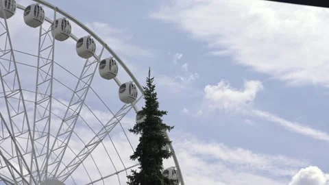 White ferris wheel rotating against blue sky with clouds Stock Footage 344236372