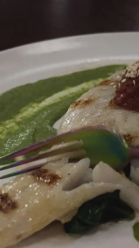 White fish in a dark restaurant with peas on the side mashed peas take with a Stock Footage 302805325