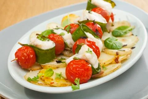 White fish kebabs monkfish cherry tomatoes snow peas Stock Photos