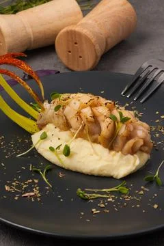 White fish with mashed potatoes on a black plate Stock Photos