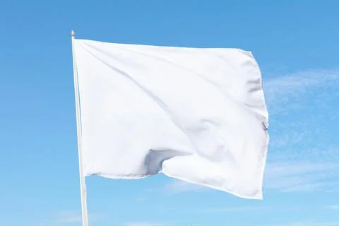 White flag billowing softly on a flagpole under sunny skies Stock Photos