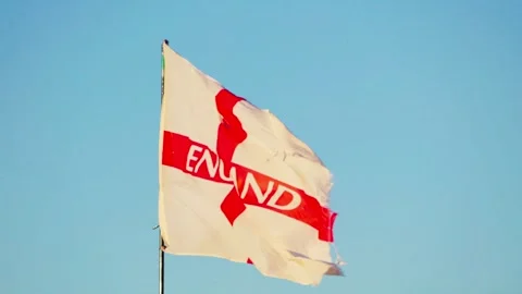 White flag with a bold red cross symbol waves against a clear blue sky. The Stock Footage 342667085