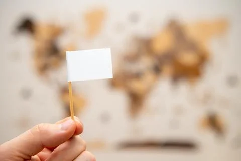 White flag with copy space in man hands with world map on the background Stock Photos