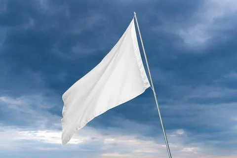 A white flag waves in the wind with dark clouds in the background Stock Photos