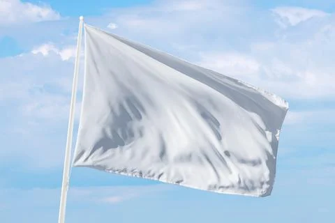 White flag waving under soft clouds, perfect for themes of surrender Stock Photos