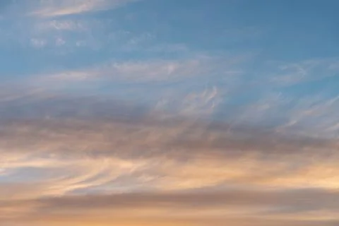 White flat and long clouds at sunset Stock Photos