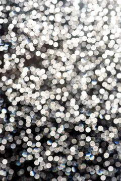 White flecks of defocused light creates a snowfall like bokeh effect in brigh Stock Photos