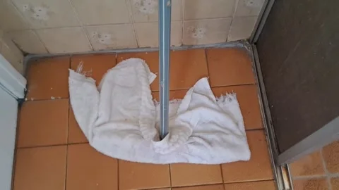 White floor mop cleaning orange tiled bathroom floor motion footage Stock Footage 336276883