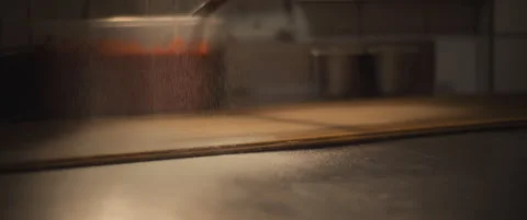 White flour is being spread over a wooden and steel surface at the pizza rest Stock Footage 146600618