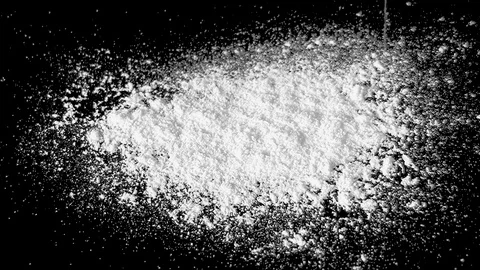 White flour falling on a black table 動画素材 104048336