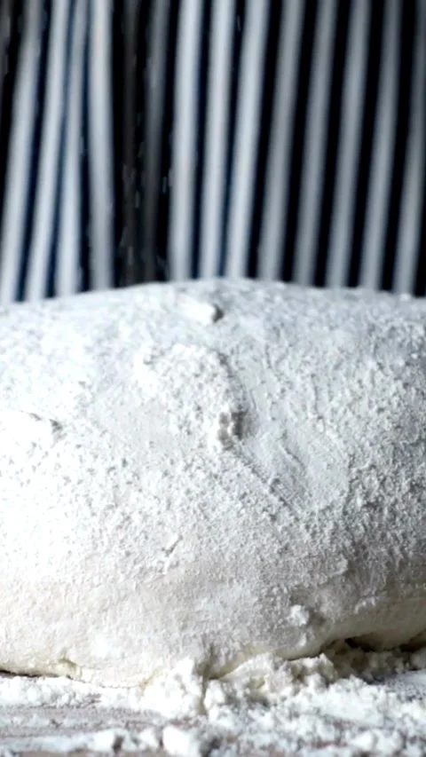 White flour falling onto raw dough in a kitchen Video stock 331934020