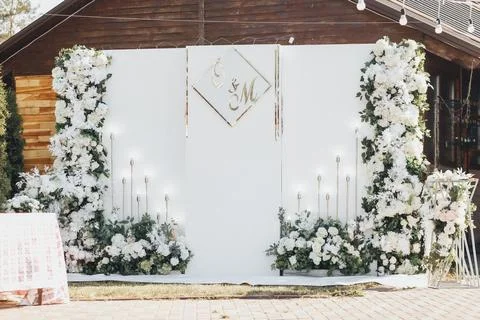 White flowers frame a wedding backdrop with elegant candles Foto stock