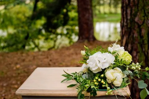 White flowers on a table in the forest. Wedding decorations. Stock Photos