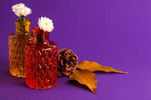 White flowers in tiny red and brown vases from glass with texture and autumn Stockfoto's