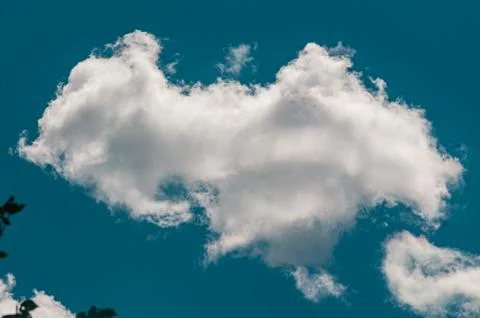 White fluffy cloud in a bright blue sky 写真素材