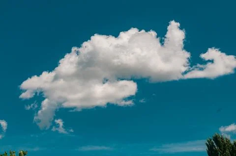 White fluffy cloud in a clear blue sky background Stock Photos