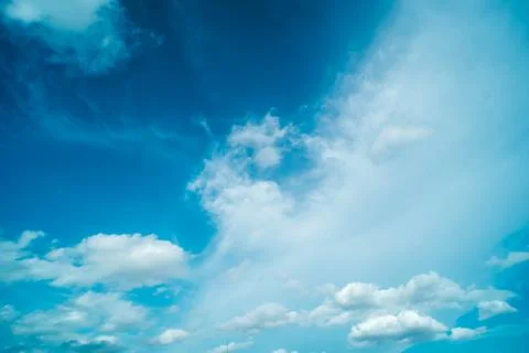White fluffy clouds against blue sky in summer nature season weather backgrou Stock Photos