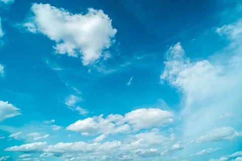 White fluffy clouds against blue sky in summer Stock Photos