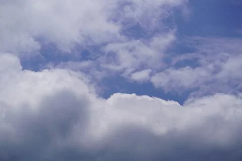 White fluffy clouds against a bright blue sky background Stock Photos