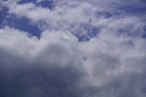 White fluffy clouds against a deep blue sky background for nature and weather Stock Photos