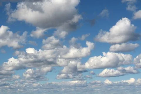 White fluffy clouds on a background of blue sky in summer. The concept of Stock Photos