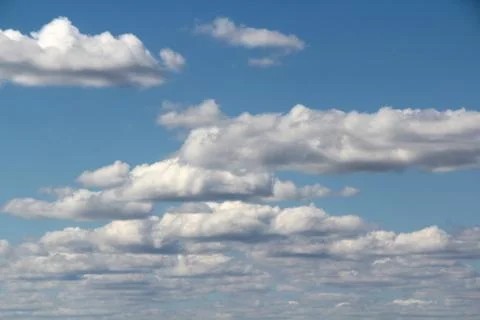 White fluffy clouds on a background of blue sky in summer. The concept of Stock Photos