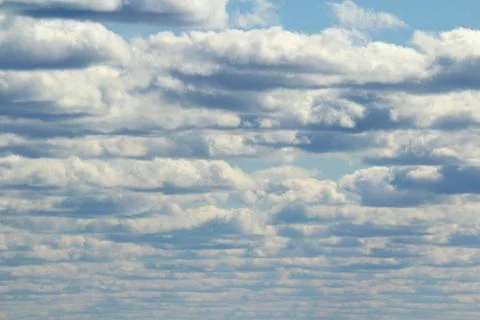 White fluffy clouds on a background of blue sky in summer. The concept of wea Stock Photos