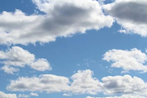 White fluffy clouds on a background of blue sky in summer. The concept of wea Stock Photos