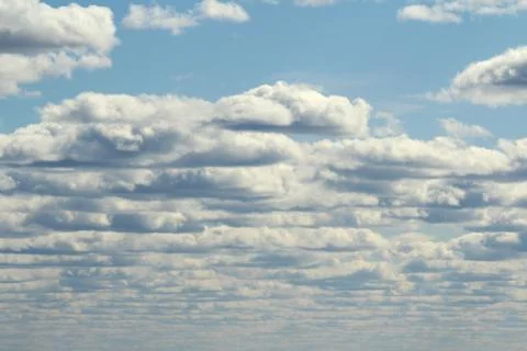 White fluffy clouds on a background of blue sky in summer. The concept of wea Stock Photos