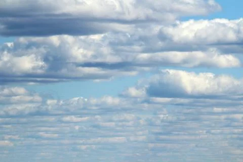 White fluffy clouds on a background of blue sky in summer. The concept of wea Stock Photos