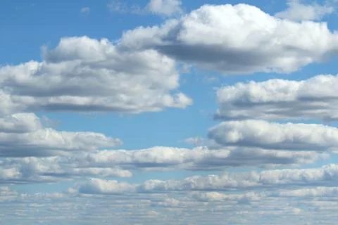 White fluffy clouds on a background of blue sky in summer. The concept of wea Stock Photos