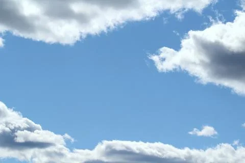 White fluffy clouds on a background of blue sky in summer. The concept of wea Stock Photos