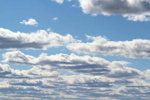 White fluffy clouds on a background of blue sky in summer. The concept of wea Stock Photos