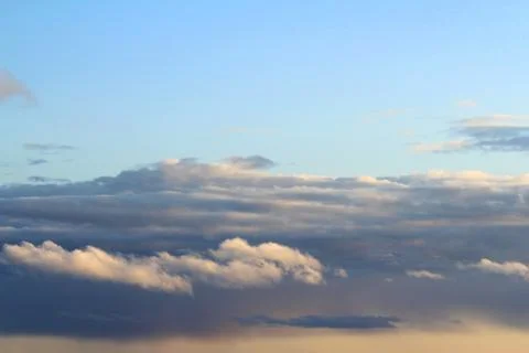 White fluffy clouds on a background of blue sky in summer. The concept of wea Stock Photos