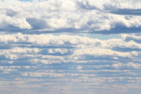 White fluffy clouds on a background of blue sky in summer. The concept of wea Stock Photos
