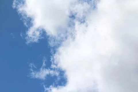 White fluffy clouds on a background of blue sky in summer. The concept of wea Stock Photos