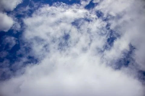 White fluffy clouds on a background of blue sky. Stock Photos