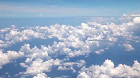 White fluffy clouds in the blue sky while flying on an airplane Stock Footage 241976343