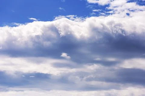 White fluffy clouds in the blue sky. Texture of clouds and sky 库存照片