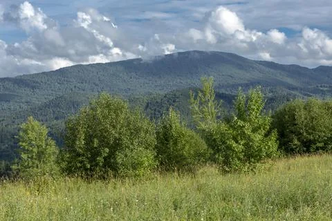 White fluffy clouds on blue sky and mountain peaks Stock Photos