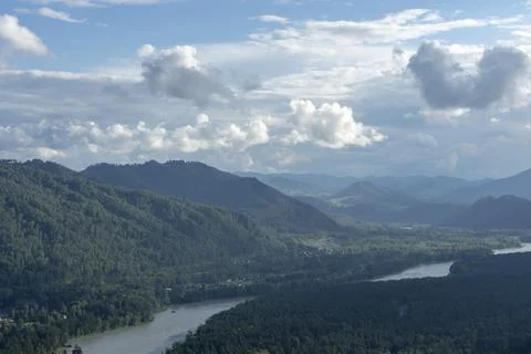 White fluffy clouds on blue sky and mountain peaks Stock Photos