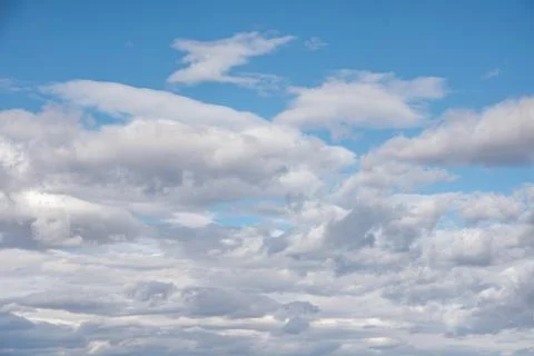White fluffy clouds in the blue sky. Sky background with the fluffy white clo Stock Photos
