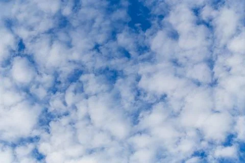 White fluffy clouds on the blue sky background. Stock Photos