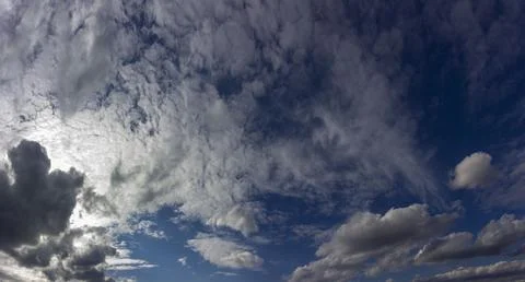 White fluffy clouds on a blue sky. Panorama of cloudy sky. Stock Photos