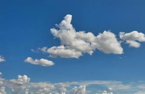 White fluffy clouds on a blue sky background Stock Photos