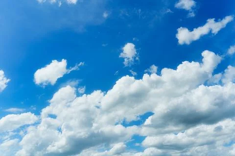 White fluffy clouds in blue sky on sunny day Stock Photos