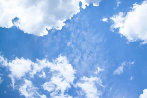 White fluffy clouds in a bright blue sky. Stock Photos