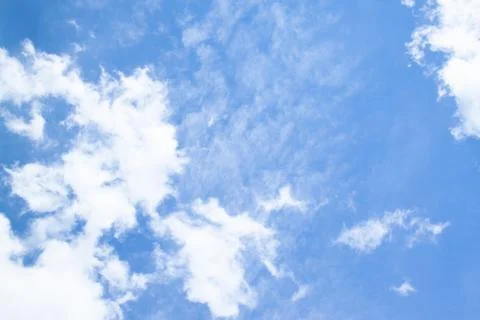 White fluffy clouds in a bright blue sky. Stock Photos