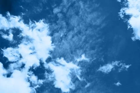 White fluffy clouds in a bright blue sky on a sunny day. Stock Photos